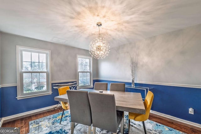 dining room featuring an inviting chandelier, baseboards, and wood finished floors