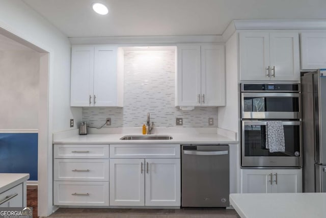 kitchen featuring appliances with stainless steel finishes, a sink, and white cabinets