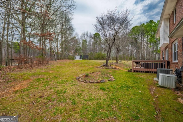 view of yard with cooling unit, an outbuilding, and a wooden deck