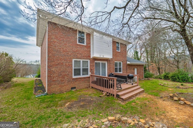 rear view of house with crawl space, a wooden deck, a lawn, and brick siding