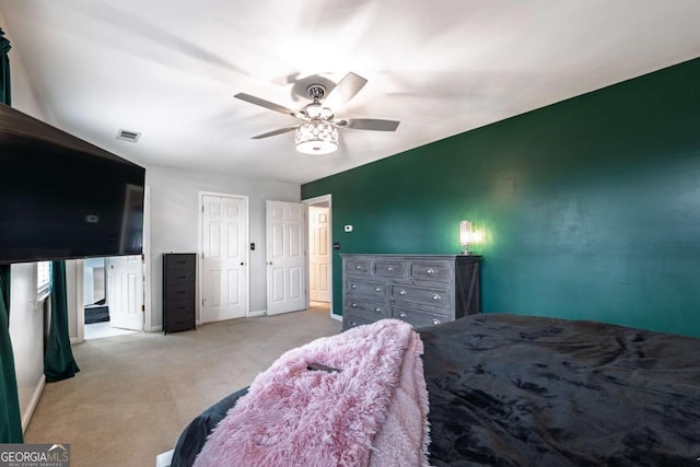 carpeted bedroom with a ceiling fan and connected bathroom