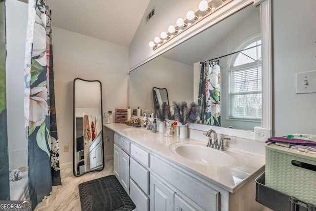 full bathroom featuring lofted ceiling, double vanity, visible vents, and a sink