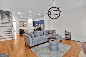 living area featuring stairs, a chandelier, wood finished floors, and recessed lighting