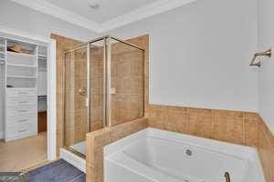 bathroom featuring crown molding, a shower stall, and a bath