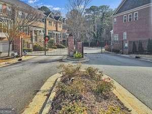 view of road featuring curbs, a gated entry, a residential view, and a gate