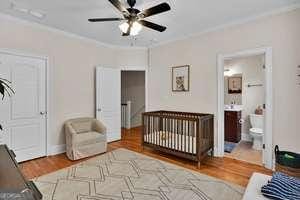 bedroom with ornamental molding, wood finished floors, and a ceiling fan