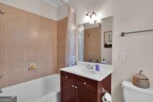 full bathroom featuring toilet, shower / tub combo, and vanity