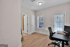 office area with light wood-style floors and baseboards