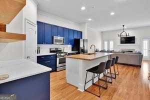 kitchen featuring light wood-style floors, a breakfast bar area, appliances with stainless steel finishes, blue cabinetry, and a sink