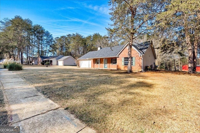 single story home with a garage, a front yard, brick siding, and a chimney