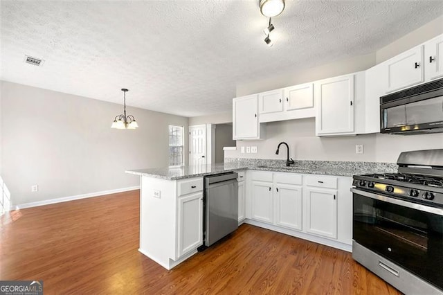 kitchen featuring stainless steel appliances, white cabinetry, a peninsula, and dark wood-style floors