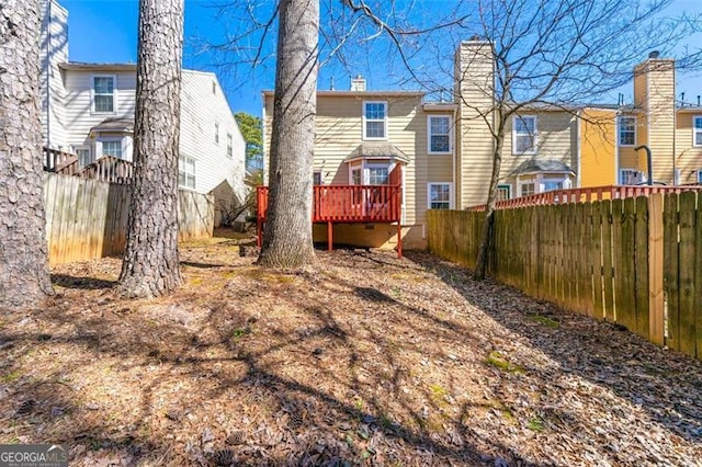 rear view of property with a deck and a fenced backyard