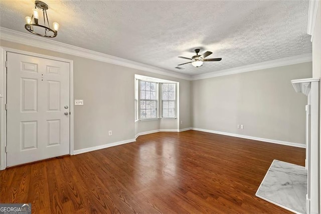 entrance foyer with a textured ceiling, ceiling fan with notable chandelier, wood finished floors, baseboards, and crown molding