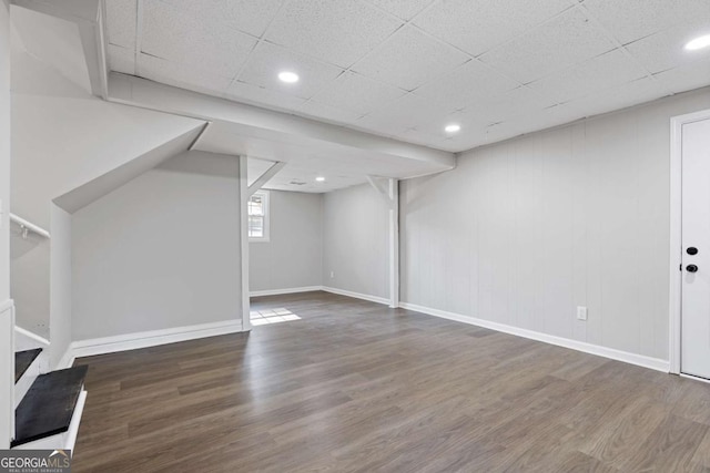 basement with a paneled ceiling, recessed lighting, baseboards, and wood finished floors