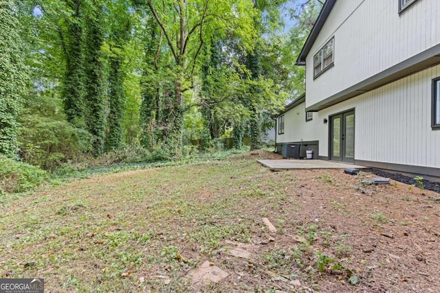 view of yard with french doors and central air condition unit