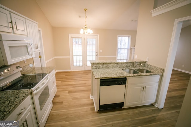 kitchen featuring light wood-style floors, white cabinetry, vaulted ceiling, a sink, and white appliances