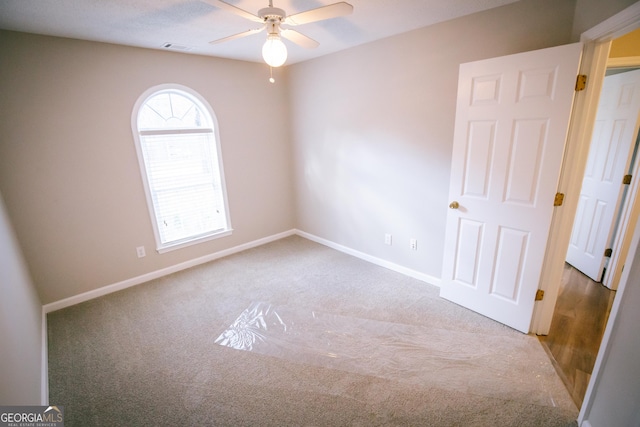 spare room with ceiling fan, carpet, visible vents, and baseboards