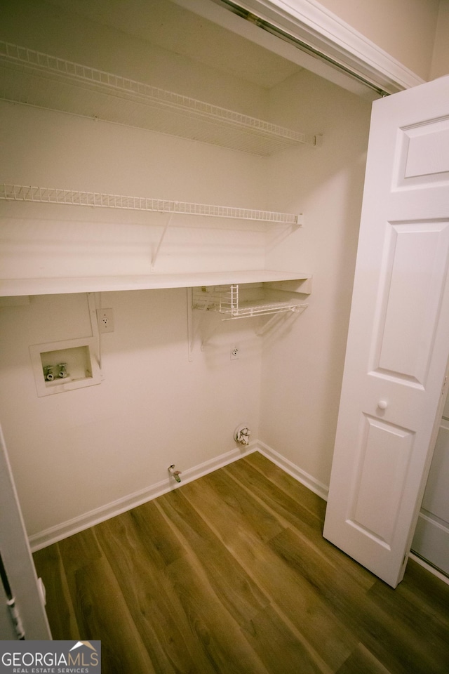 laundry area with dark wood-style floors, washer hookup, gas dryer hookup, laundry area, and baseboards