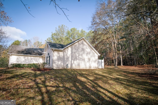 view of side of home with a yard