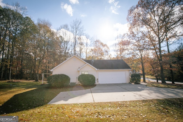 view of side of home featuring a yard, an attached garage, and driveway