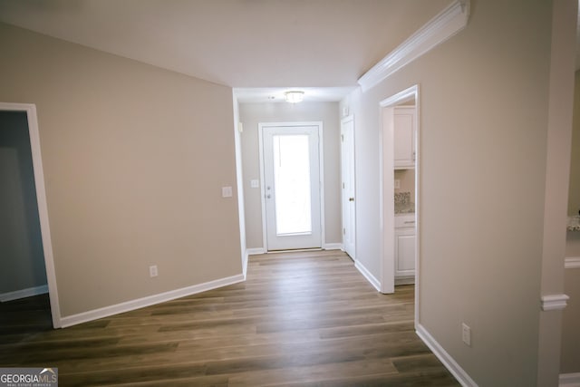 interior space with crown molding, dark wood-type flooring, and baseboards