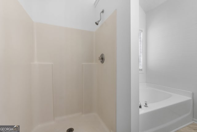 bathroom featuring a shower and a bath