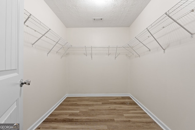 walk in closet featuring visible vents and wood finished floors