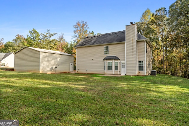 back of property with a patio area, central AC, a lawn, and a chimney