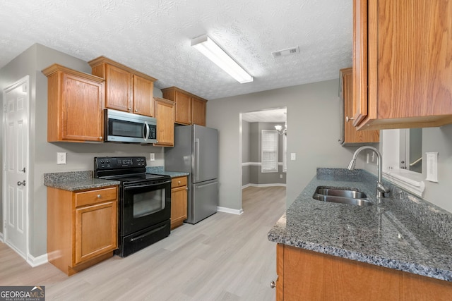 kitchen with light wood finished floors, visible vents, appliances with stainless steel finishes, and a sink