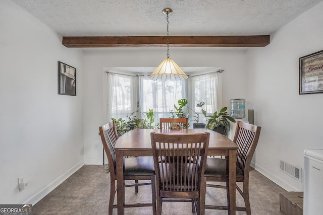 dining space with visible vents, beamed ceiling, a textured ceiling, and baseboards