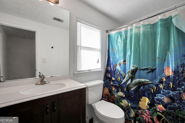 full bathroom featuring vanity, toilet, and a textured ceiling