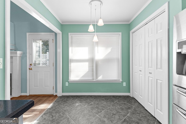 foyer entrance with baseboards and crown molding