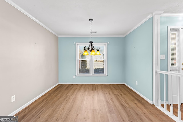 unfurnished dining area featuring baseboards, plenty of natural light, wood finished floors, and crown molding