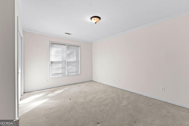 spare room featuring carpet floors, visible vents, crown molding, and baseboards