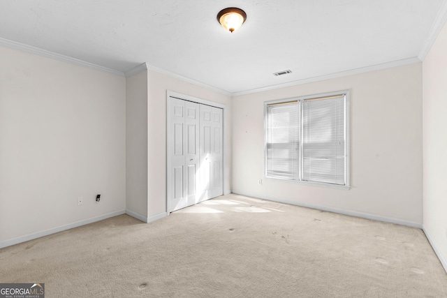 unfurnished bedroom featuring baseboards, a closet, carpet, and crown molding