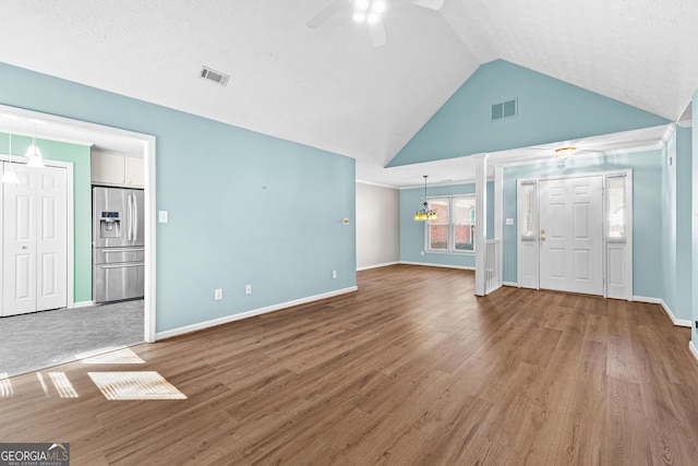 unfurnished living room featuring lofted ceiling, wood finished floors, and visible vents