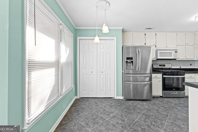 kitchen featuring visible vents, white cabinets, appliances with stainless steel finishes, dark countertops, and crown molding