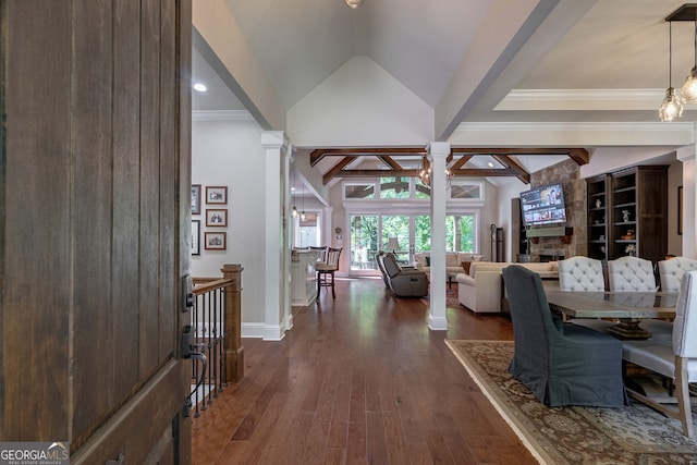 interior space with lofted ceiling with beams, dark wood-style floors, decorative columns, and baseboards