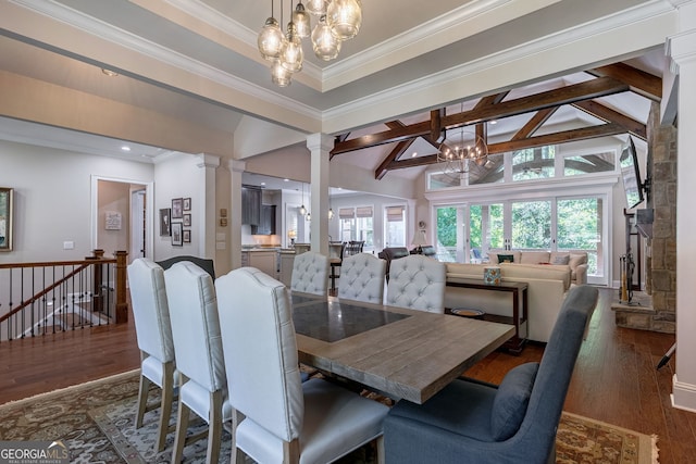 dining area with lofted ceiling with beams, ornamental molding, wood finished floors, and ornate columns