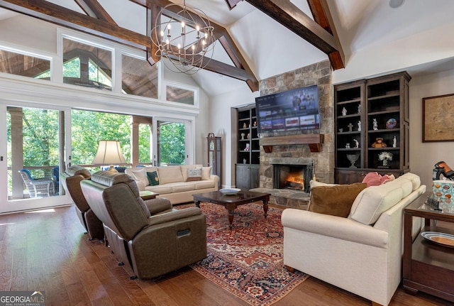 living area with wood finished floors, beamed ceiling, a fireplace, high vaulted ceiling, and a notable chandelier