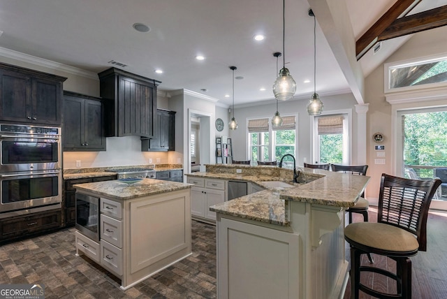 kitchen with a spacious island, plenty of natural light, appliances with stainless steel finishes, and ornamental molding