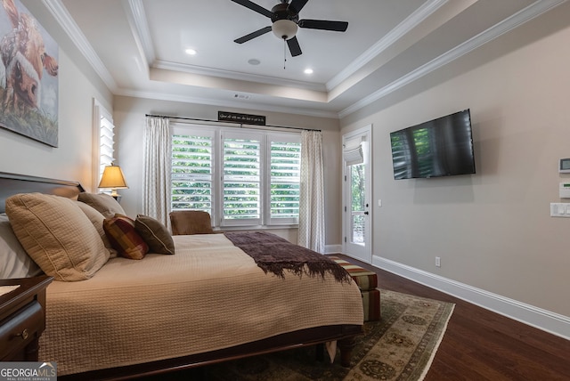 bedroom featuring access to exterior, a raised ceiling, baseboards, and wood finished floors