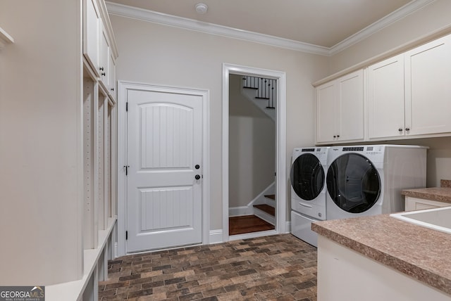 laundry area with brick floor, washing machine and dryer, baseboards, cabinet space, and crown molding