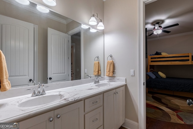 full bath featuring a sink, double vanity, a ceiling fan, and crown molding