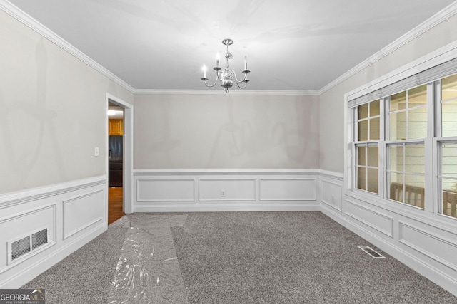 spare room featuring an inviting chandelier, carpet, visible vents, and ornamental molding