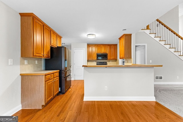 kitchen featuring stainless steel appliances, light wood-type flooring, and light countertops