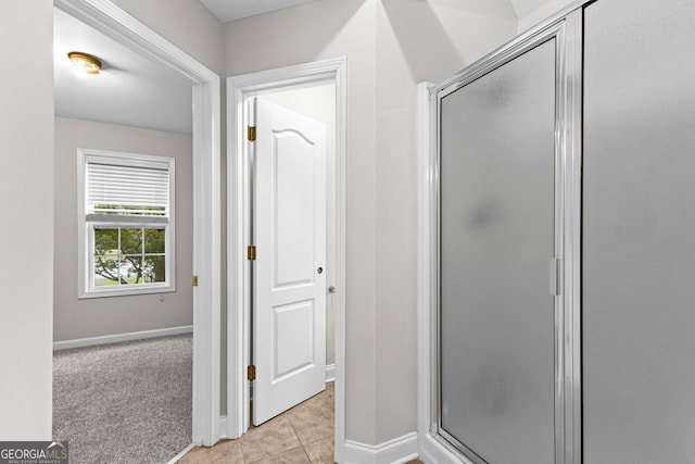 full bath featuring a stall shower, tile patterned flooring, and baseboards