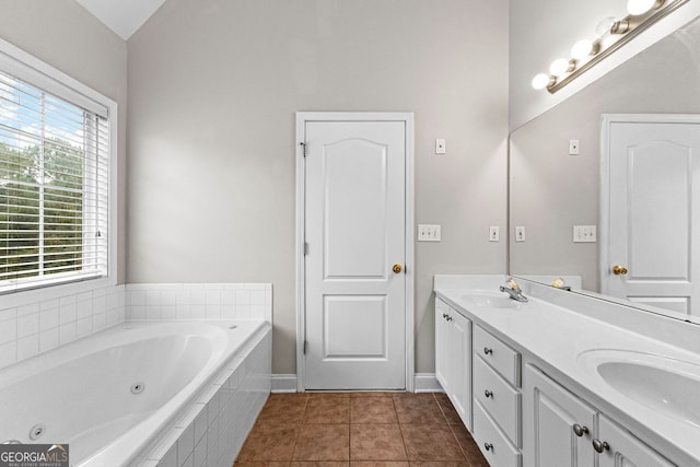 bathroom featuring double vanity, a tub with jets, tile patterned floors, vaulted ceiling, and a sink