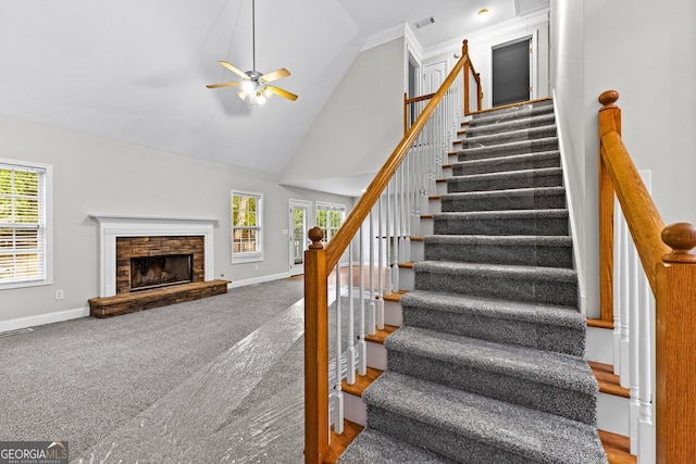 staircase with high vaulted ceiling, visible vents, a fireplace, and baseboards