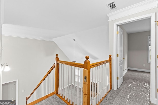 hall featuring carpet, an upstairs landing, visible vents, and baseboards